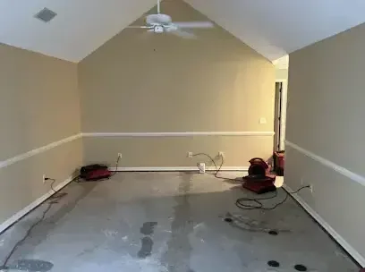 Air movers running on a bare concrete floor after the wet carpet came out