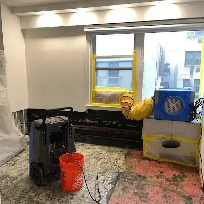 Water damage drying equipment running in a room cleared of wet materials