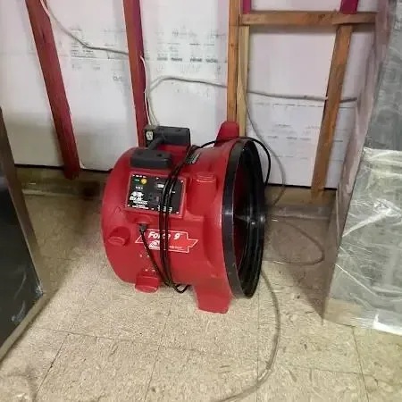 Drying equipment standing in a room stripped back to bare floor after a water loss