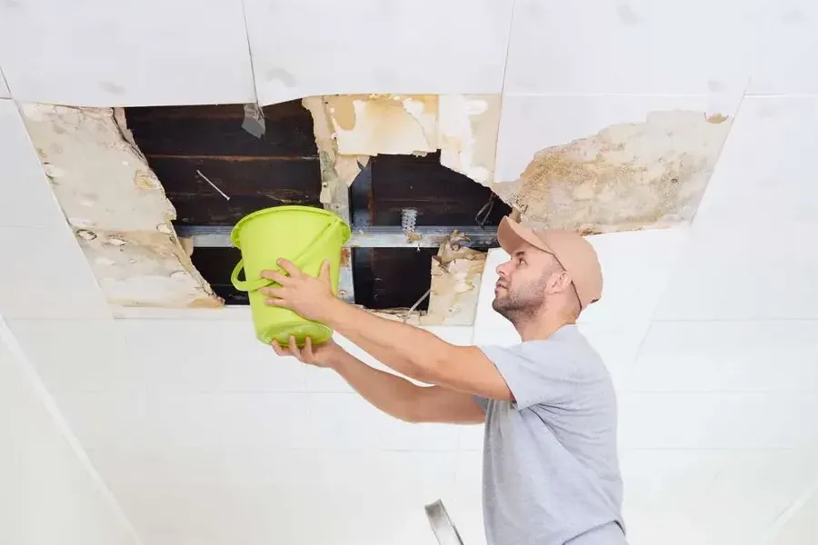 Water dripping into a bucket under an opened ceiling